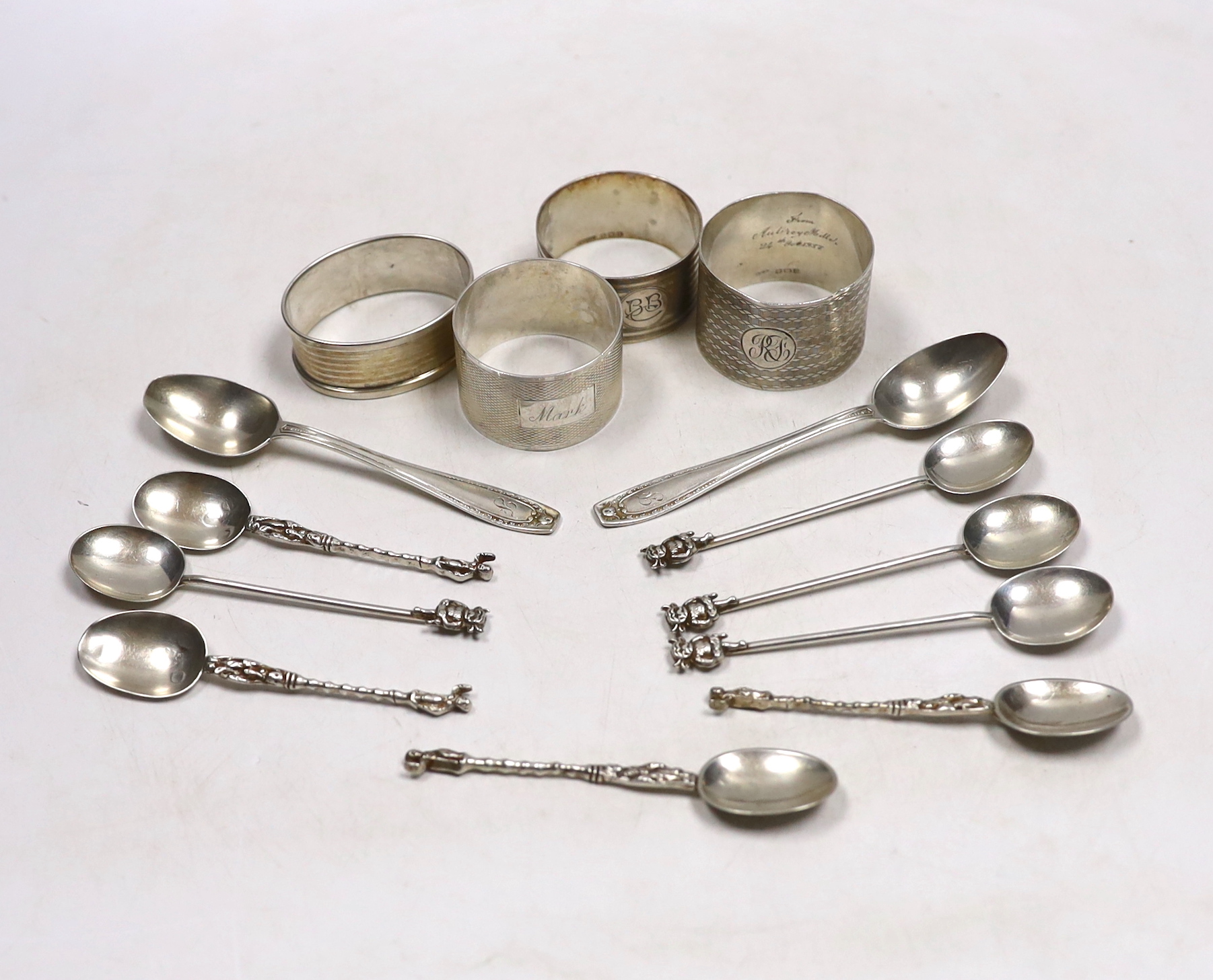 Four assorted silver napkin rings, six assorted silver coffee spoons including four with 'imp' terminals and four continental white metal coffee spoons.